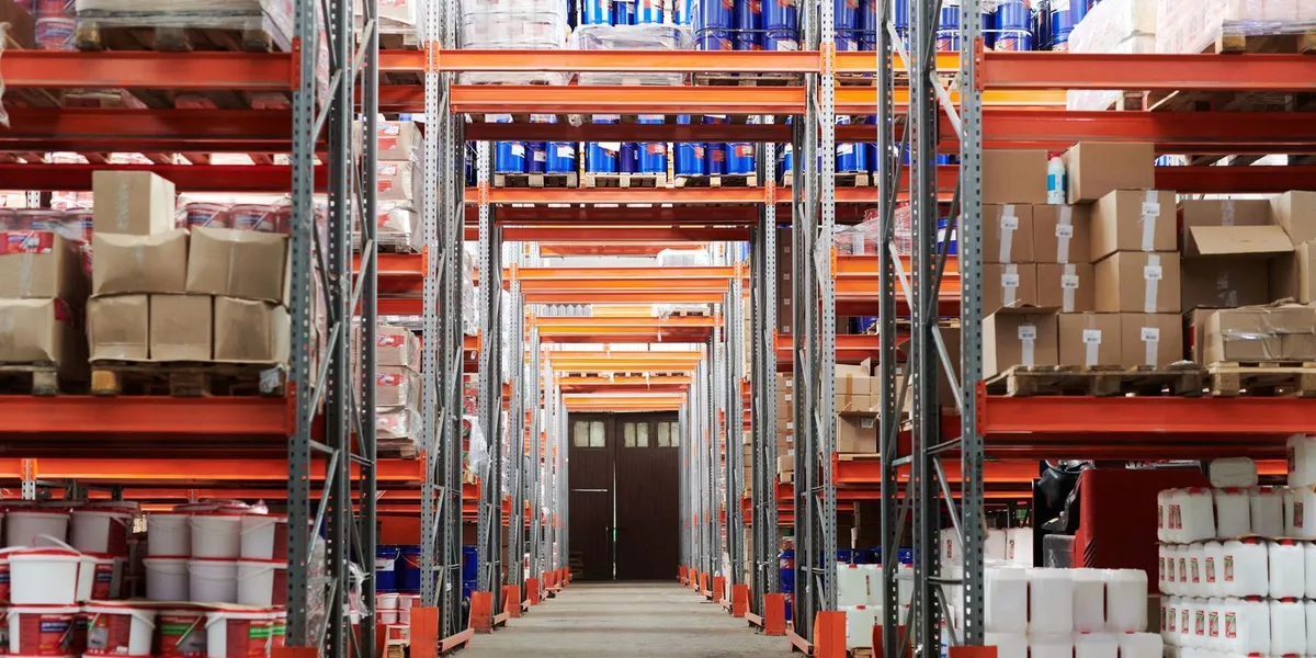 Wide angle view of a warehouse with stocked shelves and boxes.