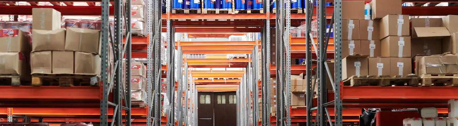 Wide angle view of a warehouse with stocked shelves and boxes.