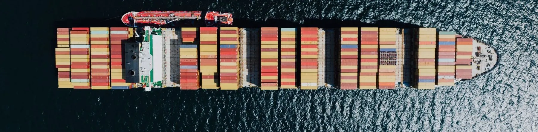 Aerial view of a container ship loaded with stacked containers at sea