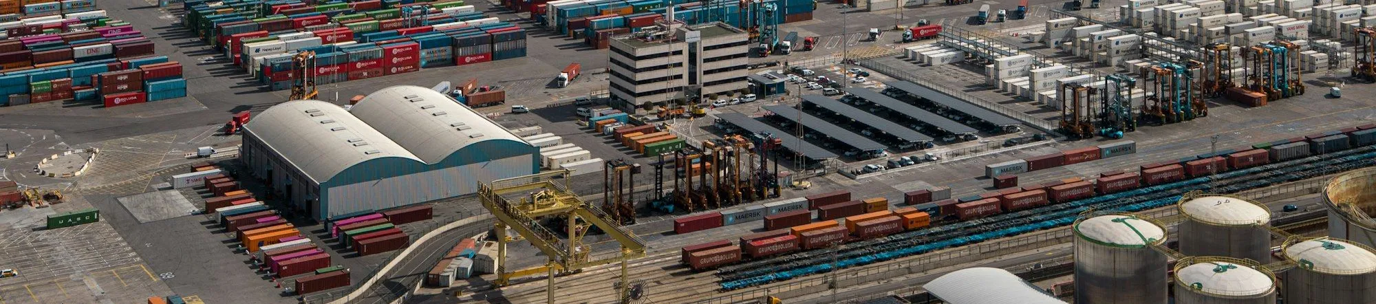 Aerial view of a busy commercial port with cargo terminals and water