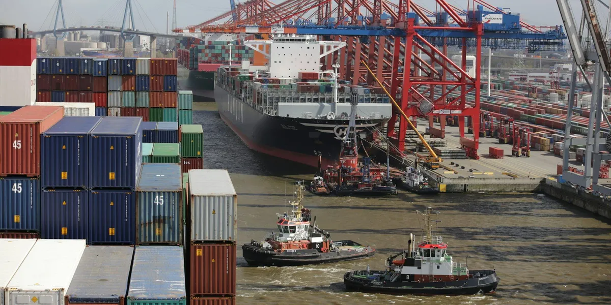 Tug boat assisting a large cargo ship into a freight port