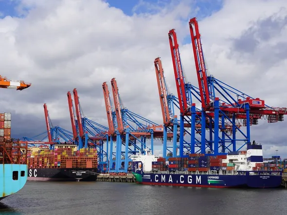 Container ships and cranes at the bustling Hamburg port, showcasing global trade activity.