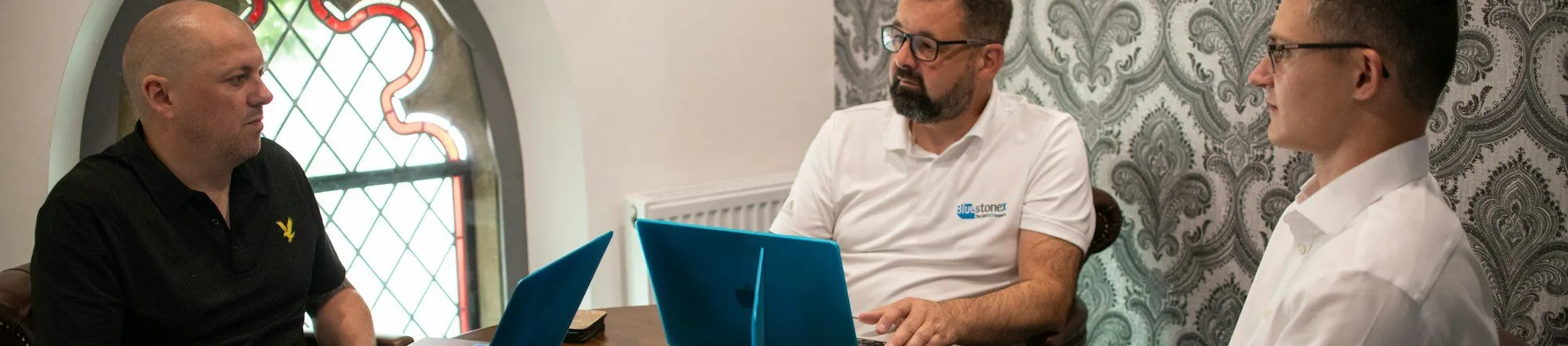 Three marketers reviewing performance data on multiple laptops