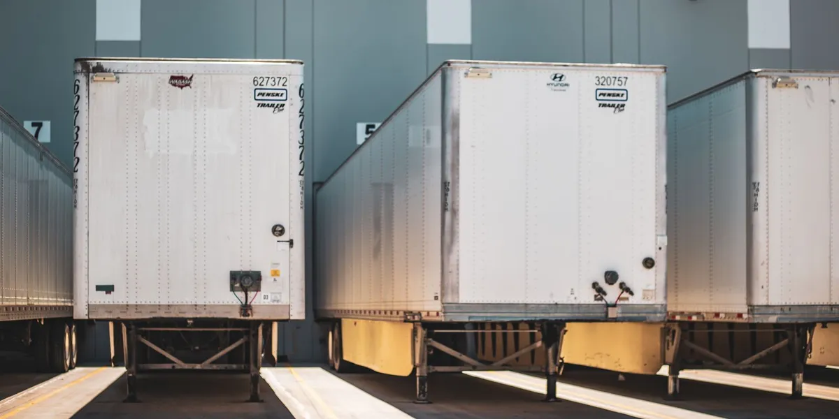 A row of freight trailers parked at a commercial loading dock, emphasizing transportation and logistics.