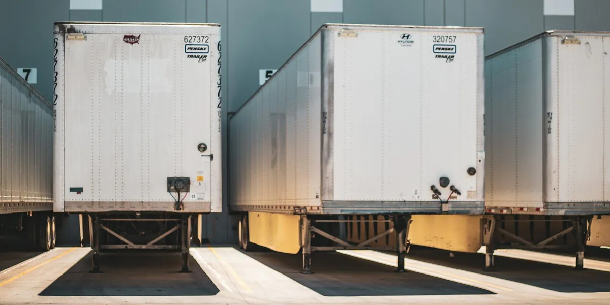 Multiple semi trucks parked next to each other at a freight depot