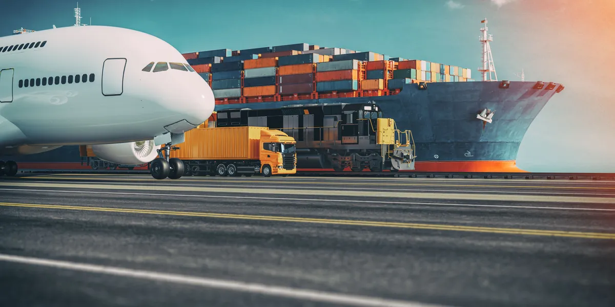 Cargo aircraft next to a container vessel and freight trucks at an intermodal terminal